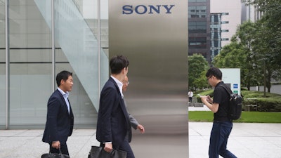 In this July 9, 2019, photo, people walk in front of the headquarters of Sony Corp., in Tokyo.