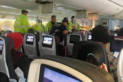 In this Thursday, July 11, 2019, photo, provided by Tim Tricky of the band Hurricane Fall, emergency workers treat a passenger on an Air Canada flight to Australia that was diverted and landed at Daniel K. Inouye International Airport in Honolulu.