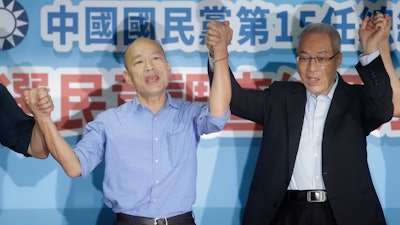 Kaohsiung city mayor Han Kuo-yu, left, celebrates with Wu Den-yih, chairman of the opposition National Party (KMT), after winning the candidacy of the opposition of the Nationalist Party (KMT), Monday, July 15, 2019, in Taipei.