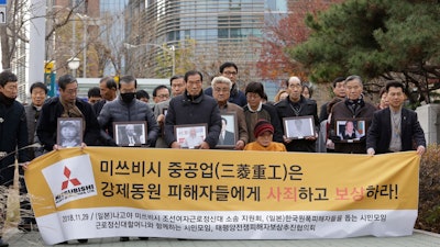 In this Nov. 29, 2018, file photo, victims of Japan's forced labor and their family members arrive at the Supreme Court in Seoul.