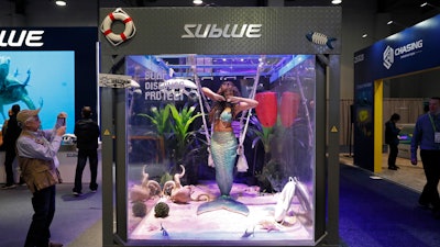In this Jan. 9, 2019, file photo a woman dressed as a mermaid performs at the Sublue booth at CES International in Las Vegas.