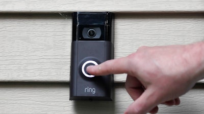 In this Tuesday, July 16, 2019, photo, Ernie Field pushes the doorbell on his Ring doorbell camera at his home in Wolcott, Conn.