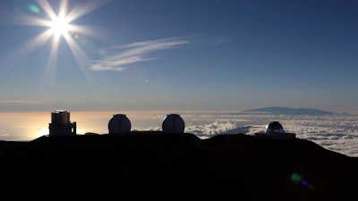 In this Sunday, July 14, 2019, file photo, the sun sets behind telescopes at the summit of Mauna Kea.