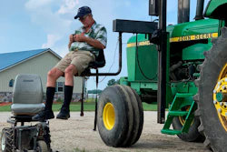 In this July 10, 2019, photo, farmer Mark Hosier, 58, uses a lift to get into a tractor on his farm in Alexandria, Ind.