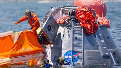 In this July 13, 2017, file photo, NASA astronaut Mike Fincke jumps into a life raft from an Orion capsule off Galveston Island, Texas.