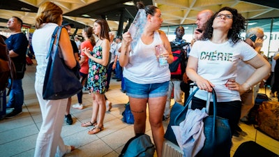 Passengers check train times at Naples' Central station, southern Italy, Monday, July 22, 2019.