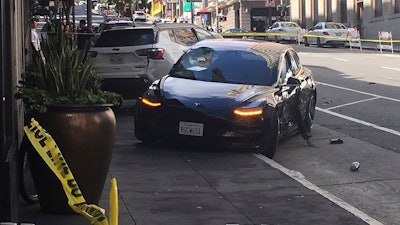This photo taken Sunday, July 21, 2019, shows the scene after a woman was arrested after running a red light in a rented Tesla in San Francisco.
