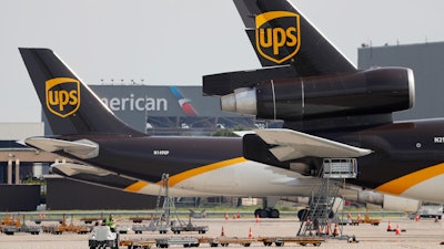 In this June 24, 2019, photo, workers prepare to unload a UPS aircraft after it arrived at Dallas-Fort Worth International Airport in Grapevine, Texas.