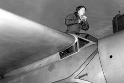 In this Jan. 13, 1935, file photo, American aviatrix Amelia Earhart climbs from the cockpit of her plane at Los Angeles, Calif.