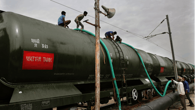 In this Wednesday, July 17, 2019, photo, workers fill wagons of a train with drinking water piped in from the Mettur dam at Jolarpet railway station, Tamil Nadu, India.