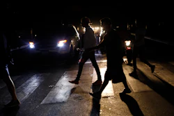 In this Monday, July 22, 2019, file photo, people walk on a street during a blackout in Caracas.
