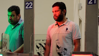 In this Thursday, July 11, 2019, photo, Palestinians stand in front of a biometric gate as they enter Israel at the Qalandia crossing in Jerusalem.