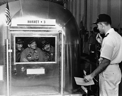 In this July 25, 1969, file photo, Capt. Carl Seiberlich, commander of the carrier Hornet, right, says goodbye to Apollo 11 astronauts Edwin Aldrin Jr., from left, Neil Armstrong and Michael Collins in Honolulu, Hawaii, before they were taken in their quarantine van to a waiting cargo plane to be flown to Houston, Texas. This week marked the 50th anniversary of the moon landing, but after those historic first steps NASA still had to get the three astronauts safely back to Earth, and the waters off Hawaii are where the cone-shaped spacecraft splashed down.