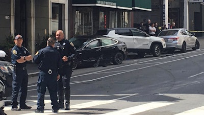 This Sunday, July 21, 2019, file photo shows the scene after a woman was arrested after running a red light in a rented Tesla in San Francisco.
