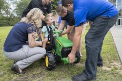 Four-year-old Jack Carroll looks up at the UWF engineering students as they help him into a vehicle that they modified for him at University of West Florida's Hal Marcus College of Science and Engineering in Pensacola on Wednesday, July 17, 2019. The modified vehicle will help Jack's mobility that is reduced due to cerebral palsy.
