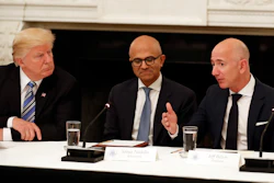 In this June 19, 2017, file photo President Donald Trump, left, and Satya Nadella, Chief Executive Officer of Microsoft, center, listen as Jeff Bezos, Chief Executive Officer of Amazon, speaks during an American Technology Council roundtable in the State Dinning Room of the White House in Washington. Amazon and Microsoft are battling for a $10 billion opportunity to build the U.S. military its first “war cloud.”