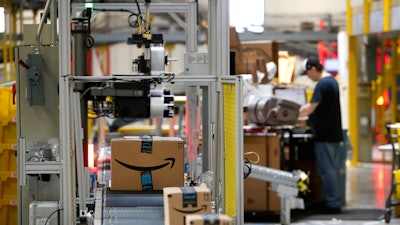 In this Aug. 3, 2017, file photo, packages pass through a scanner at an Amazon fulfillment center in Baltimore. Amazon will spend more than $700 million to provide additional training to about one-third of its U.S. workforce.