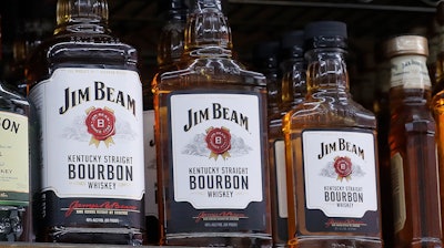 In this July 9, 2018, file photo, Bottles, Jim Beam are displayed at Rossi's Deli in San Francisco. The company behind the world's top-selling bourbon, Jim Beam, is pouring tens of millions of dollars into a new Kentucky distillery to boost production of craft whiskeys.