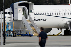 In this March 14, 2019, file photo, a worker walks next to a Boeing 737 MAX 8 airplane parked at Boeing Field in Seattle. Flyadeal, a Saudi budget carrier says it is ordering 30 new Airbus planes, replacing a $6 billion agreement it had with Boeing for its troubled 737 MAX jets, which are grounded around the world after two crashes.