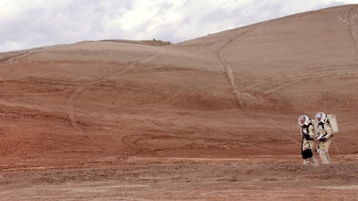 In this April 19, 2004, file photo, crew commander Gus Frederick and Greg Drayer, left, explore the terrain outside the Mars Desert Research Station northwest of Hanksville, Utah. Researchers at Brigham Young University are helping with a NASA-sponsored project measuring the electrical charge and size of dust particles on Mars.