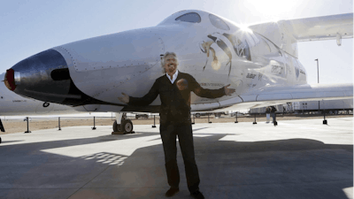 In this Sept. 25, 2013, file photo, British entrepreneur Richard Branson poses with the SpaceShipTwo at a Virgin Galactic hangar at Mojave Air and Space Port in Mojave, Calif.