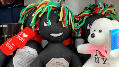This undated photo provided by New Jersey state Assemblywoman Angela McKnight shows three 'Feel Better Dolls' sharing the shelf with a stuffed animal bearing an 'I Love New York' message at a One Dollar Zone store in Bayonne, N.J. The black rag 'Feel Better' dolls that came with instructions to 'find a wall' and slam the toy against it have been pulled from three stores after customers and the lawmaker said they were offensive.