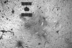 This Feb. 22, 2019, file image released by the Japan Aerospace Exploration Agency (JAXA) shows the shadow, center above, of the Hayabusa2 spacecraft after its successful touchdown on the asteroid Ryugu. Japan’s space agency JAXA said Thursday, July 11, 2019 that data transmitted from the Hayabusa2 indicated its second successful touchdown on the distant asteroid to complete a historic mission - to collect underground samples in hopes of finding clues to the origin of the solar system.