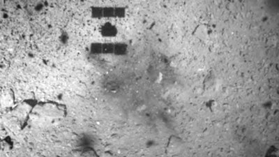 This Feb. 22, 2019, file image released by the Japan Aerospace Exploration Agency (JAXA) shows the shadow, center above, of the Hayabusa2 spacecraft after its successful touchdown on the asteroid Ryugu. Japan’s space agency JAXA said Thursday, July 11, 2019 that data transmitted from the Hayabusa2 indicated its second successful touchdown on the distant asteroid to complete a historic mission - to collect underground samples in hopes of finding clues to the origin of the solar system.