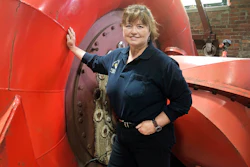 In this June 5, 2019 photo, Natural Power Group co-owner Sarah Bower-Terbush stands in front of a power turbine at the company's hydroelectric site in Wappingers Falls, N.Y. She and her husband sell renewable power to local customers from three hydroelectric sites they operate in the Hudson Valley. Customers say they like investing their money locally in clean power.