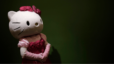 In this Thursday, Oct. 30, 2014 file photo, a model dressing as Japanese character Hello Kitty waits for guests to pose for a souvenir photo at Sanrio Puroland, a theme park featuring Hello Kitty in Tokyo. European Union antitrust authorities have fined the Japanese company behind Hello Kitty for restricting cross-border sales of toys, mugs, bags and other products featuring the cartoon cat girl. The EU’s antitrust commissioner, Margrethe Vestager, said Sanrio was fined 6.2 million euros ($7 million) because the company violated the bloc’s competition rules.