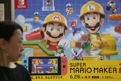 A woman walks by an advertisement poster of a Nintendo in Tokyo in Tokyo, Tuesday, July 9, 2019. Nintendo Co. says it plans to start making its Switch console in Vietnam this year, transferring some of its production from China.