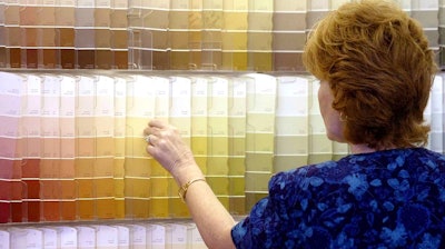 In this June 28, 2004, file photo, a customer looks over color chips at a Sherwin-Williams store in Columbus, Ohio. The nation's major suppliers of lead paint have agreed to pay California's largest cities and counties $305 million to settle a nearly two-decade old lawsuit. The settlement announced Wednesday, July 17, 2019, comes after years of legal and legislative battling in California and other states. The settlement is with the Sherwin-Williams Company, ConAgra Grocery Products Company and NL Industries, Inc.