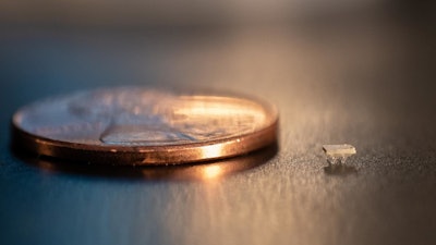 A micro-bristle-bot is shown next to a US penny for size comparison.