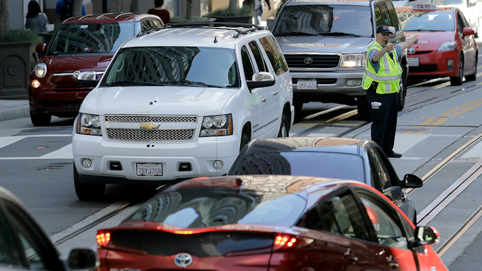 In this April 21, 2017, file photo, a San Francisco Municipal Transit Agency officer directs traffic in San Francisco.