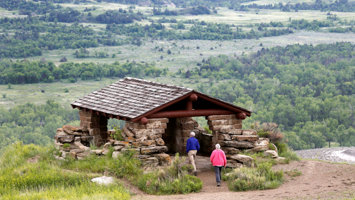 In this June 11, 2014, file photo, visitors hike to a stone lookout over the Little Missouri River inside the Theodore Roosevelt National Park, North Dakota.