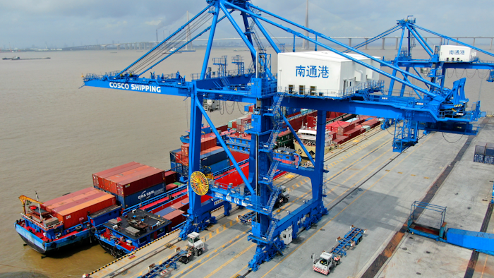 In this July 18, 2019, file photo, shipping containers are loaded onto a cargo ship at a port in Nantong, China.