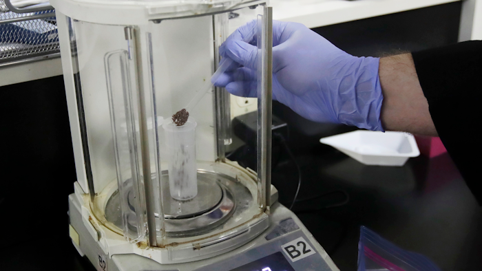 In this Friday, Aug. 16, 2019, photo, chemist David Dawson pours pieces of a cannabis-infused chocolate bar into a vial as he demonstrates testing for THC and other chemicals at CW Analytical Laboratories in Oakland, Calif. Chemists are trying to solve a scientific mystery involving marijuana brownies. Chocolate seems to throw off test results for potency. That could be dangerous for consumers looking to relax, not hallucinate.