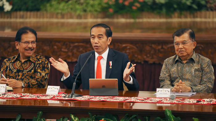 Indonesian President Joko Widodo, center, speaks alongside deputy Jusuf Kalla, right, and Minister of Agrarian and Spatial Planning Sofyan Djalil in Jakarta, Monday, Aug. 26, 2019.