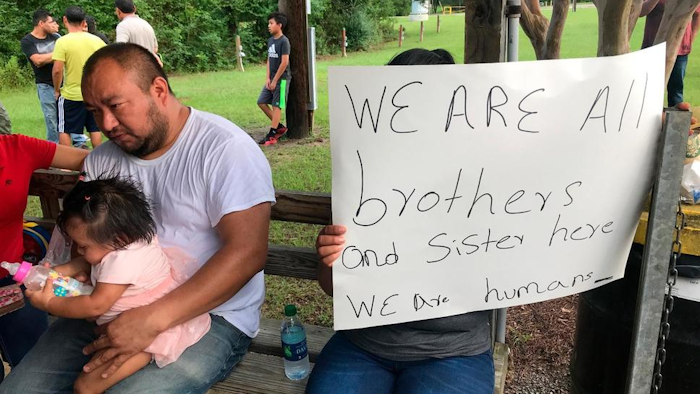 Workers from PH Foods and their supporters gather at a protest on Tuesday, Aug. 13, 2019 in Morton, Miss., after workers from the chicken processing plant said they were fired. Workers say the plant fired the majority of remaining workers days after federal agents arrested 99 people there for immigration violations.