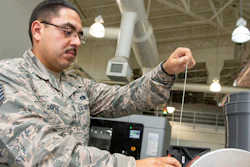 U.S. Air Force Tech. Sgt. Rogelio Lopez, 60th Maintenance Squadron assistant aircraft metals technology section chief, loads Ultem 9085 material into a canister for use in the Stratasys F900 three-dimensional printer, Aug. 15, 2019, Travis Air Force Base, Calif.