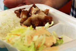 In this Thursday, March 14, 2019, photo, Belinda Lau, manager of the Wiki Wiki Drive Inn takeout restaurant in Honolulu, holds a polystyrene foam box containing an order of roast pork, rice and salad.