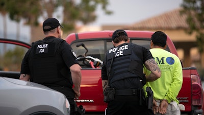 In this July 8, 2019, file photo, U.S. Immigration and Customs Enforcement officers detain a man during an operation in Escondido, Calif.