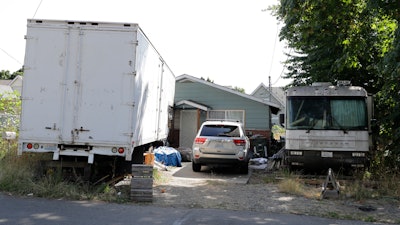 Vehicles are parked outside the home of Paige A. Thompson, who uses the online handle 'erratic,' Wednesday, July 31, 2019, in Seattle. Thompson was taken into custody Monday at her home and has been charged with computer fraud and abuse in connection with hacking data from more than 100 million Capital One credit holders or applicants.