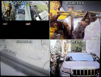 In this image made from a Monday, July 29, 2019, security camera video provided by a neighbor who has requested not to be identified, federal agents conduct a raid on the home of Paige A. Thompson in Seattle. Thompson is accused of accessing the personal information of millions of Capital One credit card holders or credit card applicants in the U.S. and Canada. The time and date stamp on the image is inaccurate, as the raid took place on Monday, July 29, 2019.