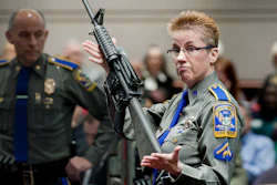 In this Jan. 28, 2013, file photo, firearms training unit Detective Barbara J. Mattson of the Connecticut State Police holds up a Bushmaster AR-15 rifle during a hearing of a legislative subcommittee in Hartford, Conn.