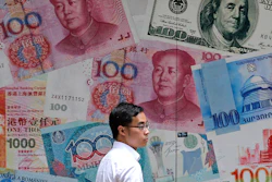 In this June 10, 2019, file photo, a man walks past a money exchange shop in Hong Kong.