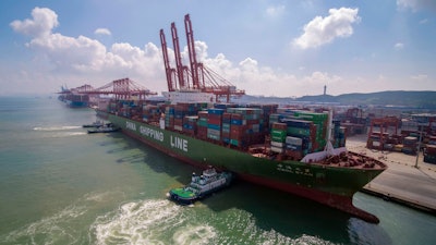 In this Aug. 6, 2019, photo, tugboats manuever a container ship at a port in Qingdao in eastern China's Shandong province.