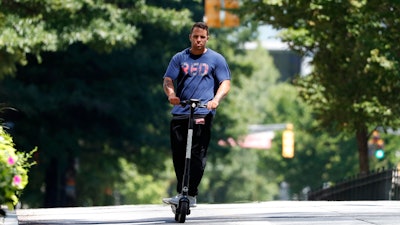A man rides an electric scooter Thursday, Aug. 8, 2019, in Atlanta.