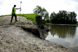 In this Tuesday, Aug. 6, 2019, photo, U.S. Army Corps of Engineers worker Ron Allen uses a GPS tool to survey the extent of damage where a levee failed along the Missouri River near Saline City, Mo.