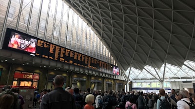 People wait for trains at King's Cross station in London, Saturday, Aug. 10, 2019.